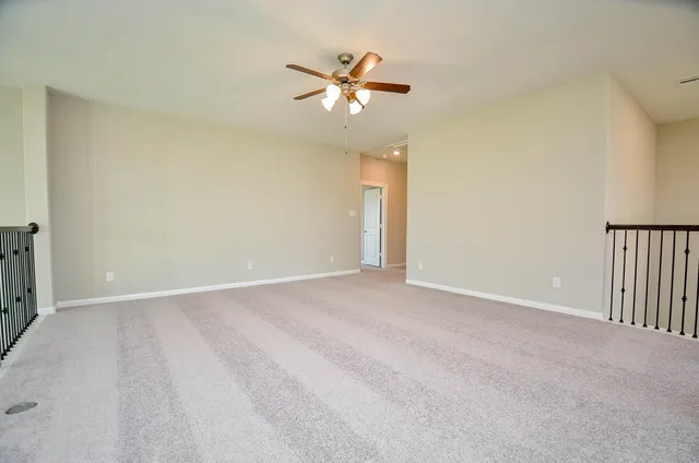 a view of an empty room with a ceiling fan