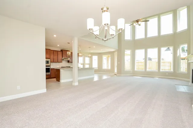 a view of an empty room with kitchen view and living room view