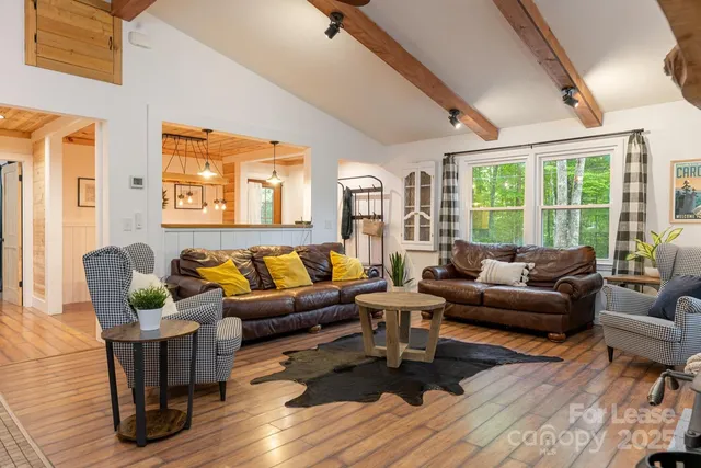 a living room with furniture wooden floor and a large window