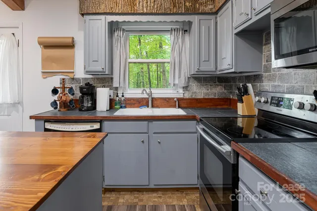 a kitchen with stainless steel appliances granite countertop a sink stove and cabinets