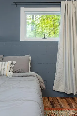 a bed sitting in a bedroom next to a window