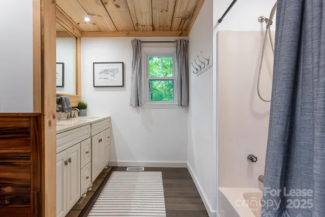 a bathroom with a sink a window and shower