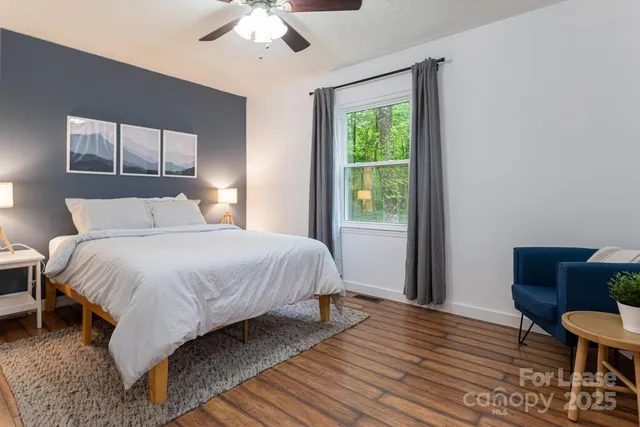 a bedroom with a bed a chandelier and window