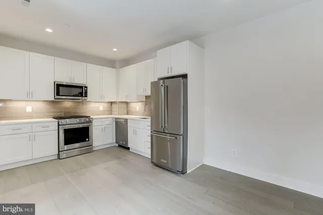 a kitchen with cabinets and stainless steel appliances