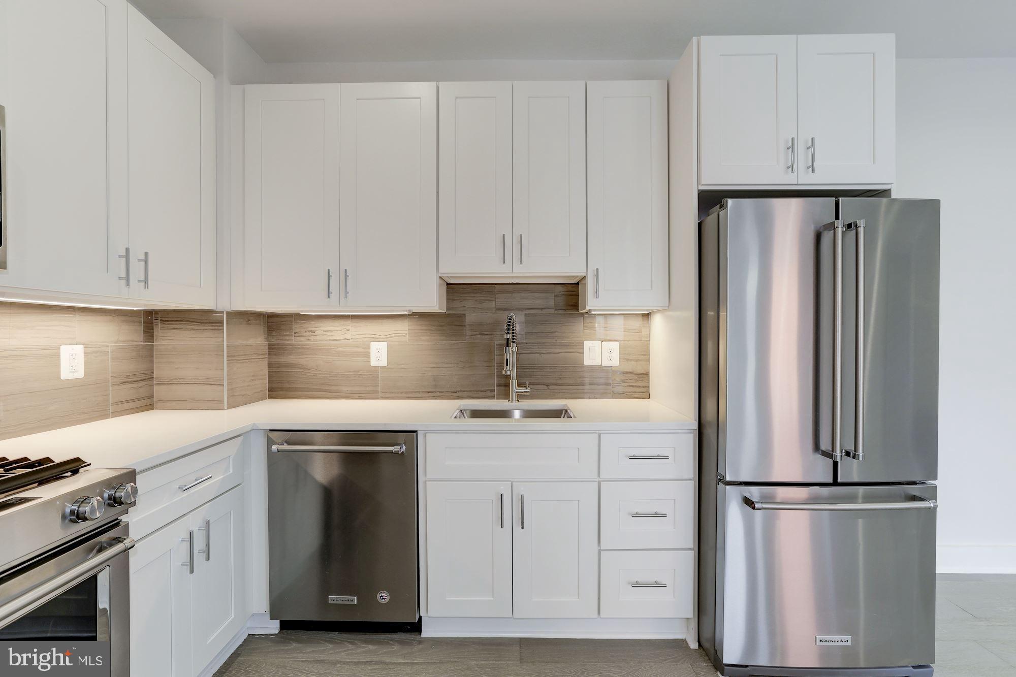 4008 Edmunds Street Northwest, Unit 9 Washington, DC 20007 - Photo 2 of 30 a kitchen with stainless steel appliances granite countertop a refrigerator sink and white cabinets
