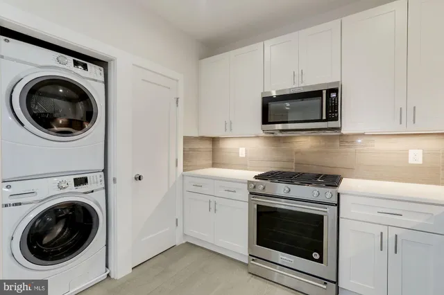 a kitchen with microwave a stove and cabinets