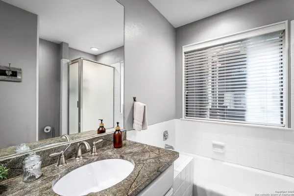 a bathroom with a granite countertop sink a toilet and a mirror