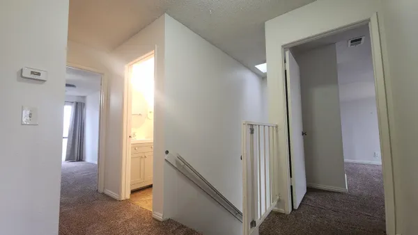 a view of a hallway with a livingroom and a bathroom