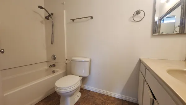 a white toilet sitting next to a bath tub
