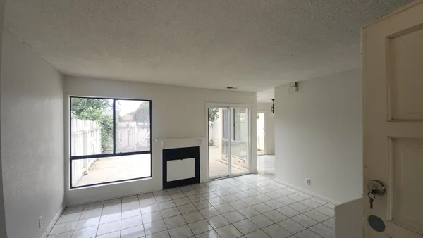 a view of an empty room with a fireplace and a window