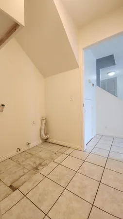 a view of a room with white wall and a refrigerator