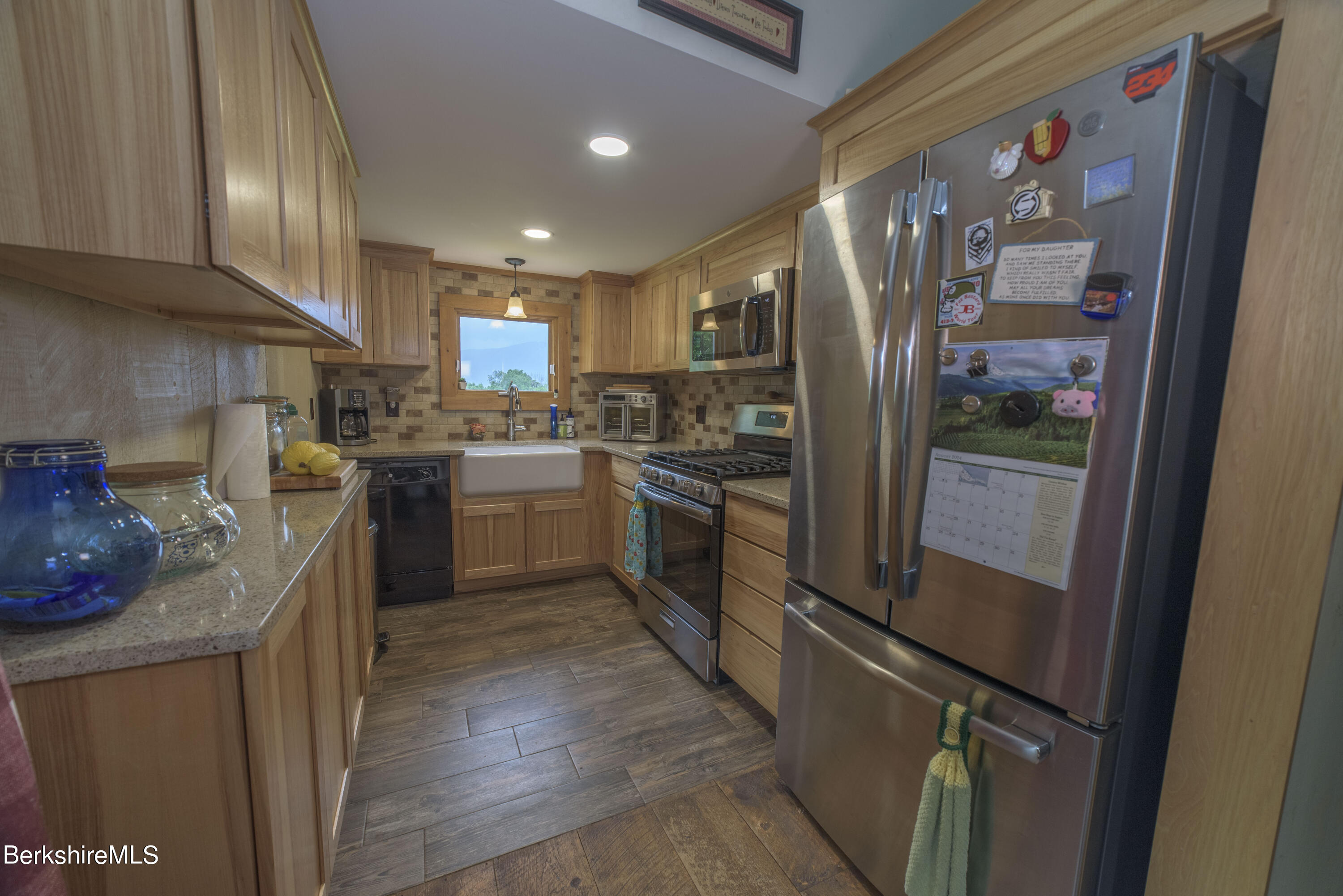 65 East Mountain Road Adams, MA 01220 - Photo 4 of 21 a kitchen with stainless steel appliances granite countertop a refrigerator a sink dishwasher a stove and a dining table with wooden floor