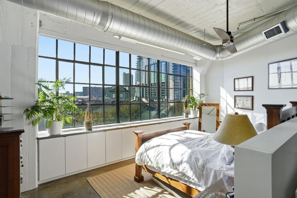 2220 Canton Street, Unit 407 Dallas, TX 75201 - Photo 16 of 39 a bed sitting in a bedroom next to a balcony