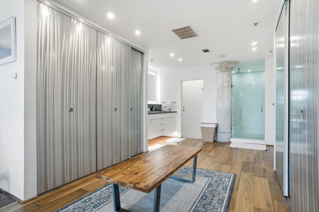 2220 Canton Street, Unit 407 Dallas, TX 75201 - Photo 21 of 39 a view of a hallway with wooden floor and a bathroom