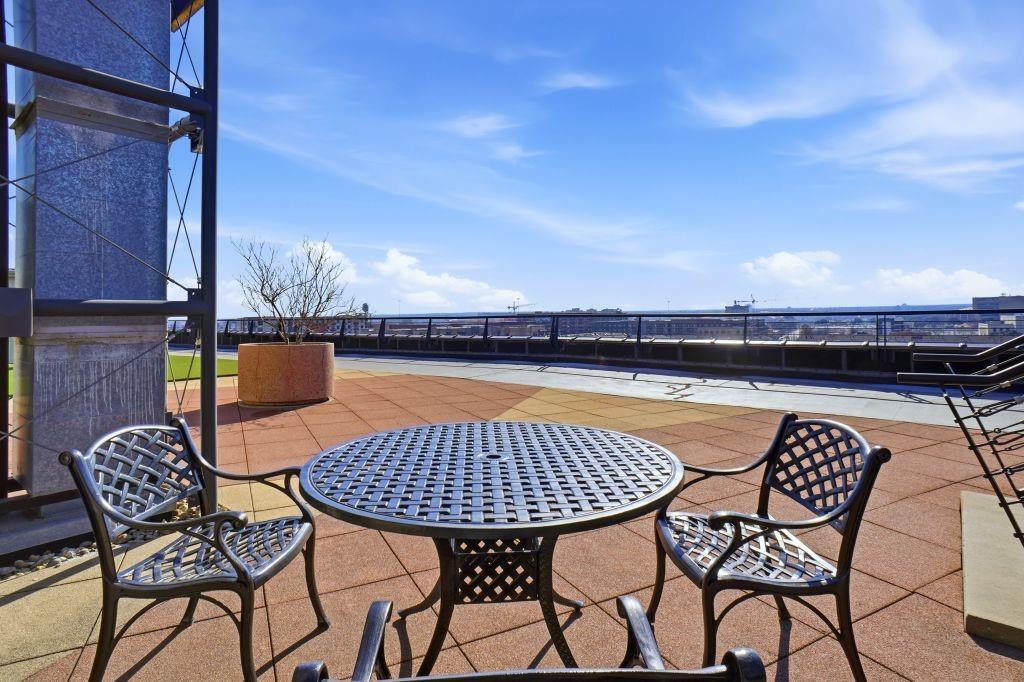 2220 Canton Street, Unit 407 Dallas, TX 75201 - Photo 32 of 39 a view of a roof deck with table and chairs with wooden floor and fence
