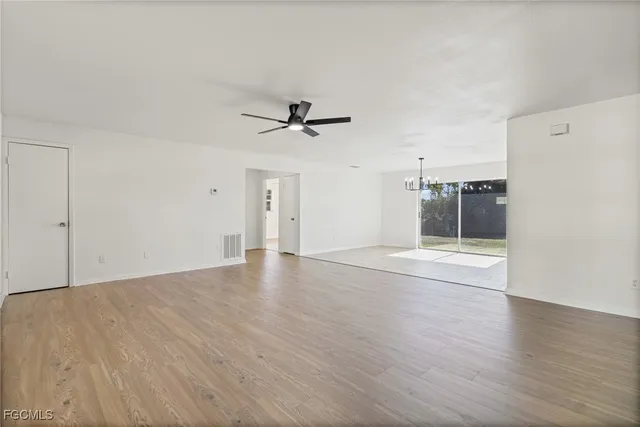 a view of a livingroom with wooden floor and a ceiling fan