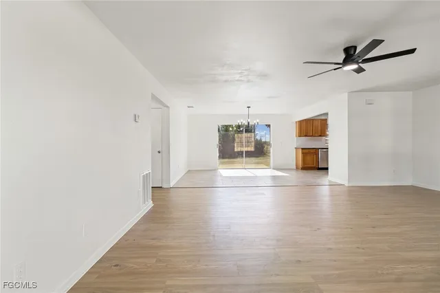 a view of empty room with wooden floor and window