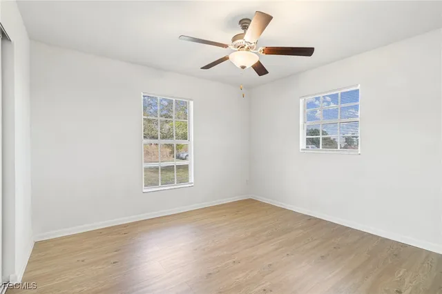 a view of a big room with wooden floor and windows
