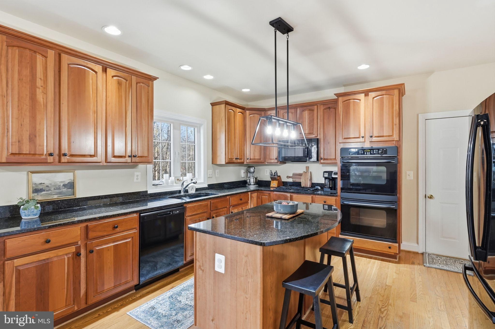2171 Towles Road Midland, VA 22728 - Photo 21 of 58 a kitchen with stainless steel appliances granite countertop wooden floor sink stove and refrigerator