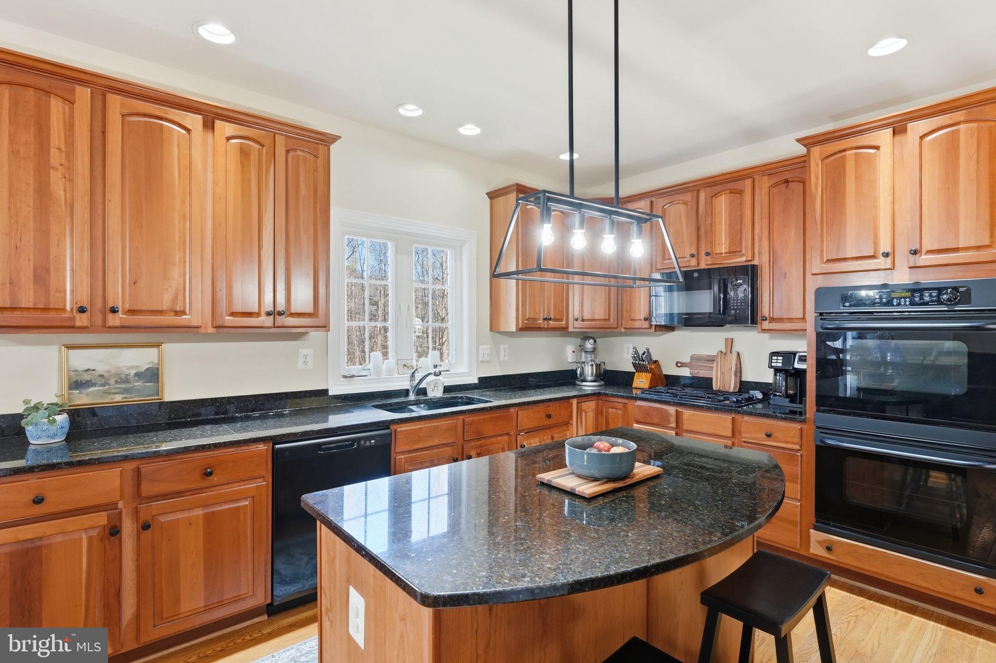 2171 Towles Road Midland, VA 22728 - Photo 22 of 58 a kitchen with stainless steel appliances granite countertop a sink a microwave and wooden cabinets
