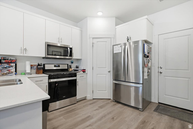 1213 West 1820th Street South Logan, UT 84321 - Photo 6 of 18 Contemporary kitchen with light wood-finish flooring, white cabinetry, and light-toned countertops
