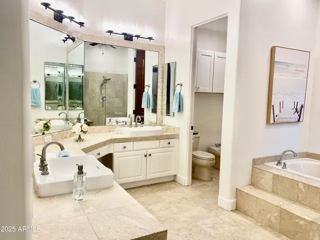 a spacious bathroom with a double vanity sink a mirror a bathtub and a shower