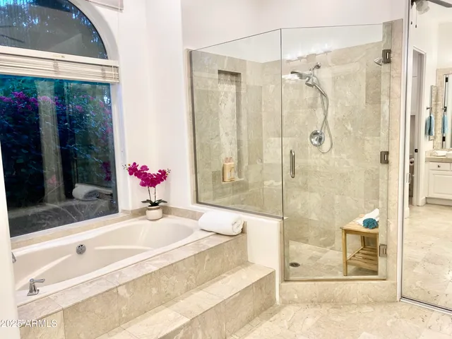 a bathroom with a granite countertop shower and a mirror