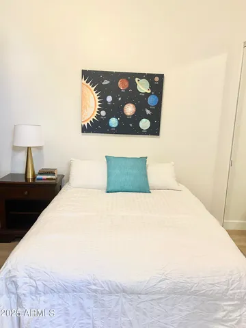 a bedroom with a bed and a wall painting