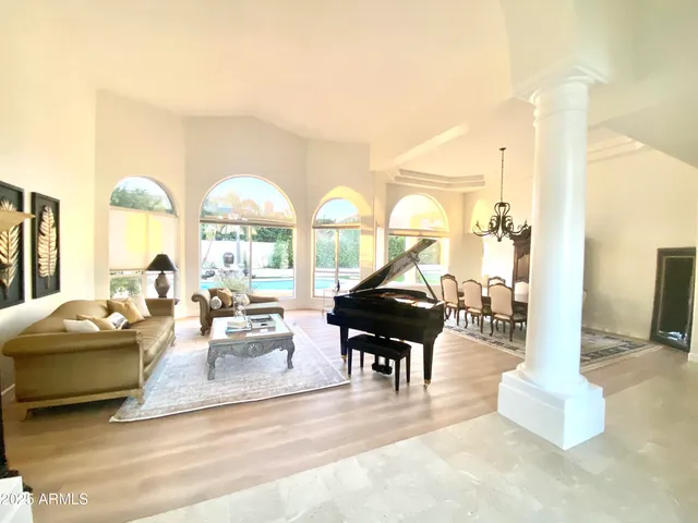 a living room with fireplace furniture and a large window