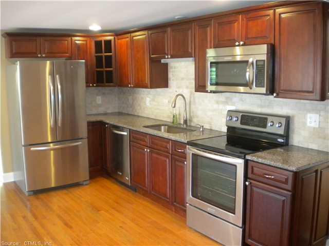 a kitchen with stainless steel appliances granite countertop a refrigerator stove and sink