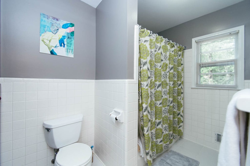 652 Bass Road Macon, GA 31210 - Photo 22 of 25 a white toilet sitting next to a shower curtain