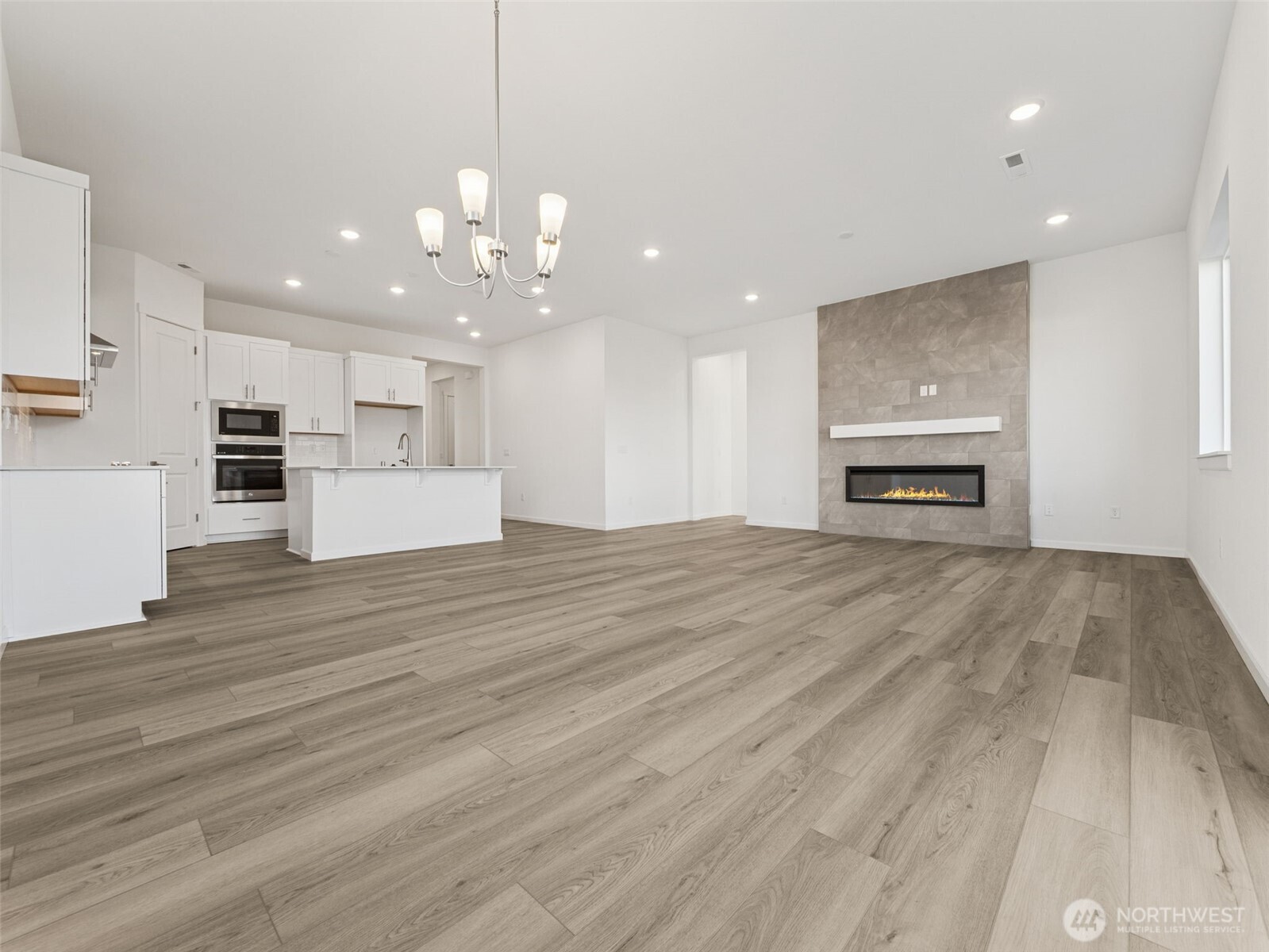 749 South Davis Street, Unit 104 Buckley, WA 98321 - Photo 5 of 11 a view of empty room with wooden floor and kitchen