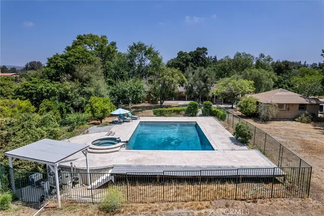 a view of a swimming pool with a patio and a yard