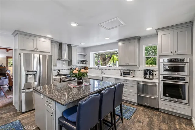 a kitchen with kitchen island granite countertop a stove cabinets and refrigerator