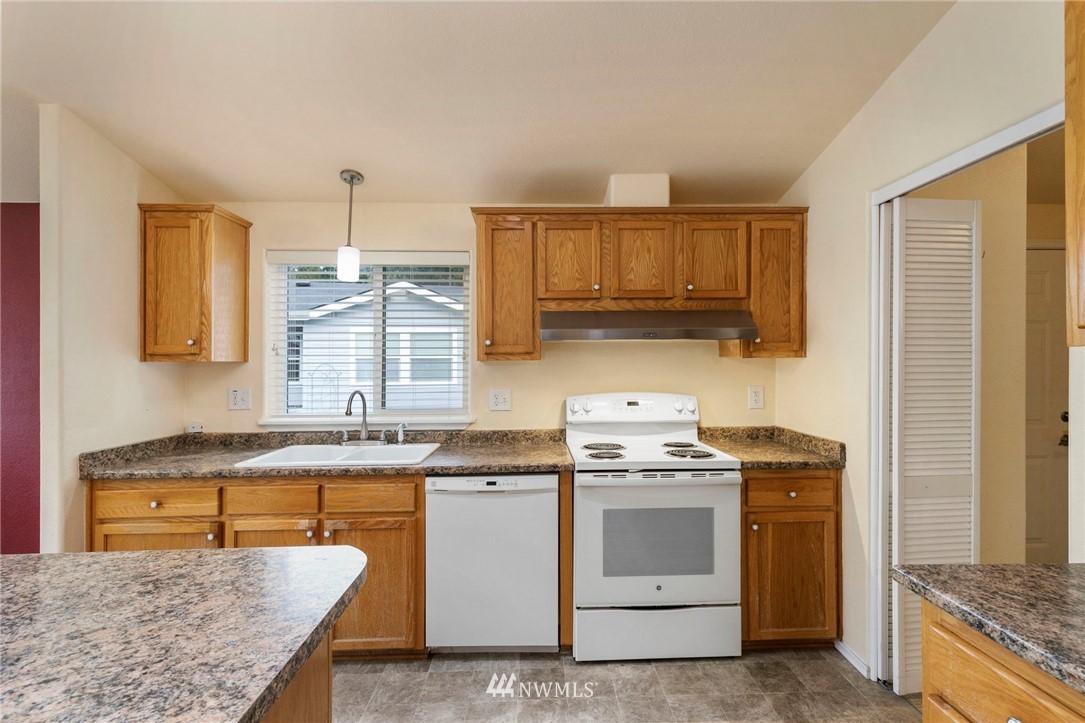 3532 Sylvan Pines Circle Bremerton, WA 98310 - Photo 13 of 22 a kitchen with stainless steel appliances granite countertop a stove a sink and a refrigerator