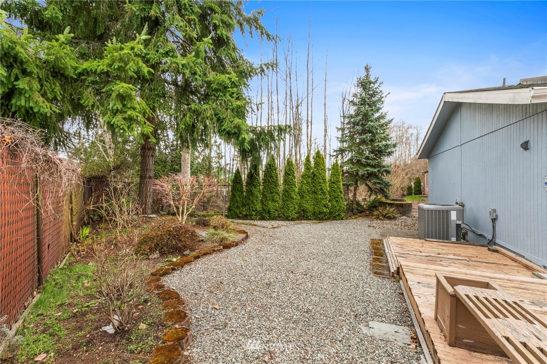 3532 Sylvan Pines Circle Bremerton, WA 98310 - Photo 21 of 22 a backyard of a house with plants and trees with wooden fence
