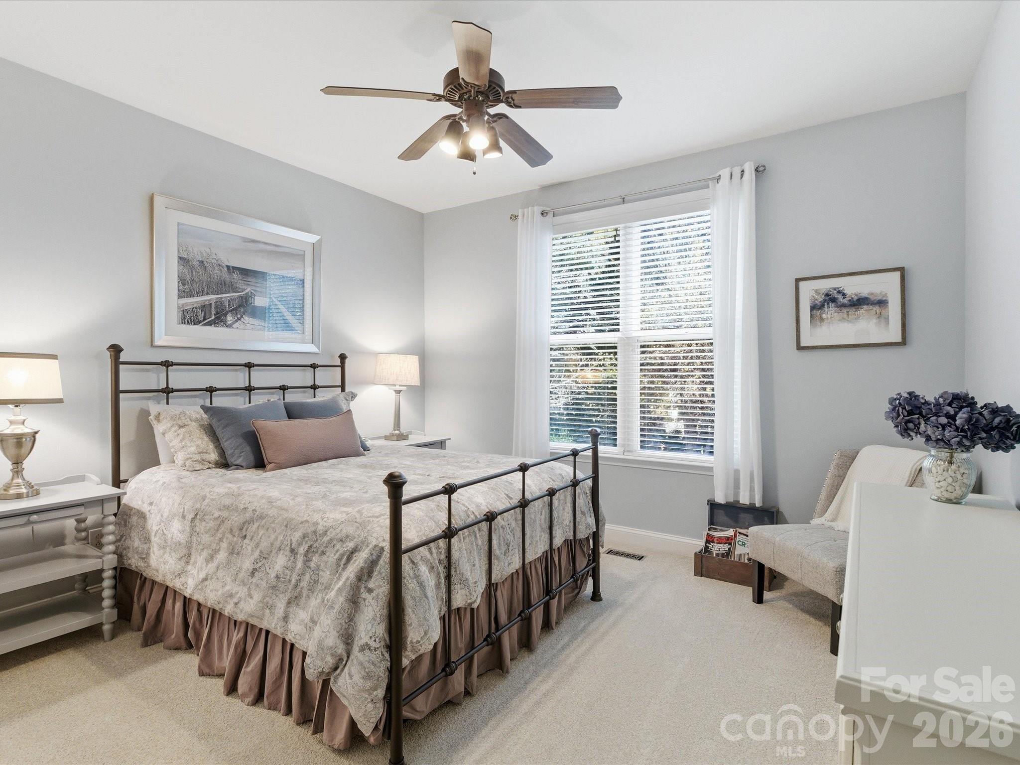 6318 Riverside Oaks Drive Huntersville, NC 28078 - Photo 11 of 48 a bedroom with a bed and a chandelier