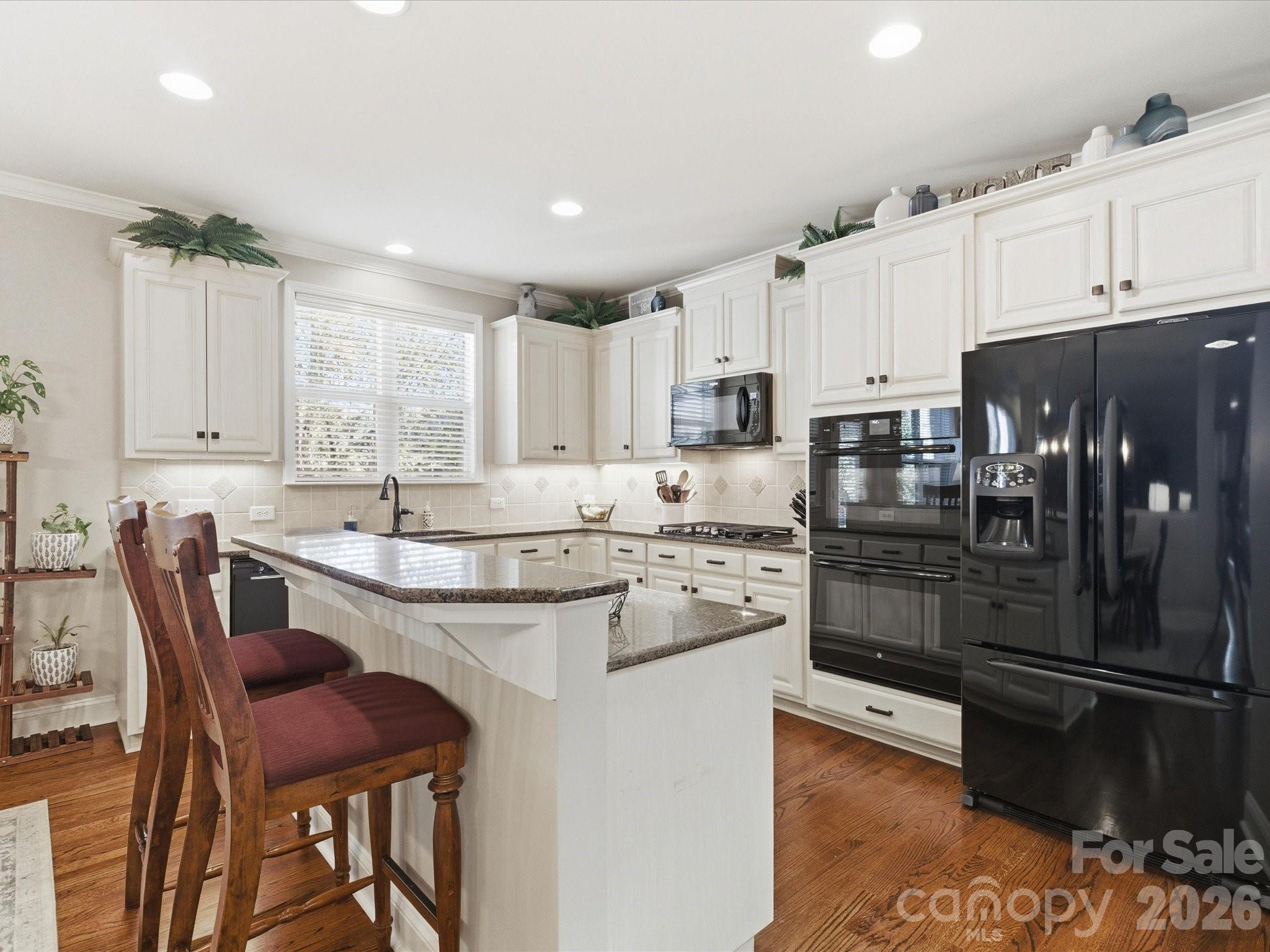 6318 Riverside Oaks Drive Huntersville, NC 28078 - Photo 16 of 48 a kitchen with stainless steel appliances granite countertop a stove top oven a sink a refrigerator and white cabinets