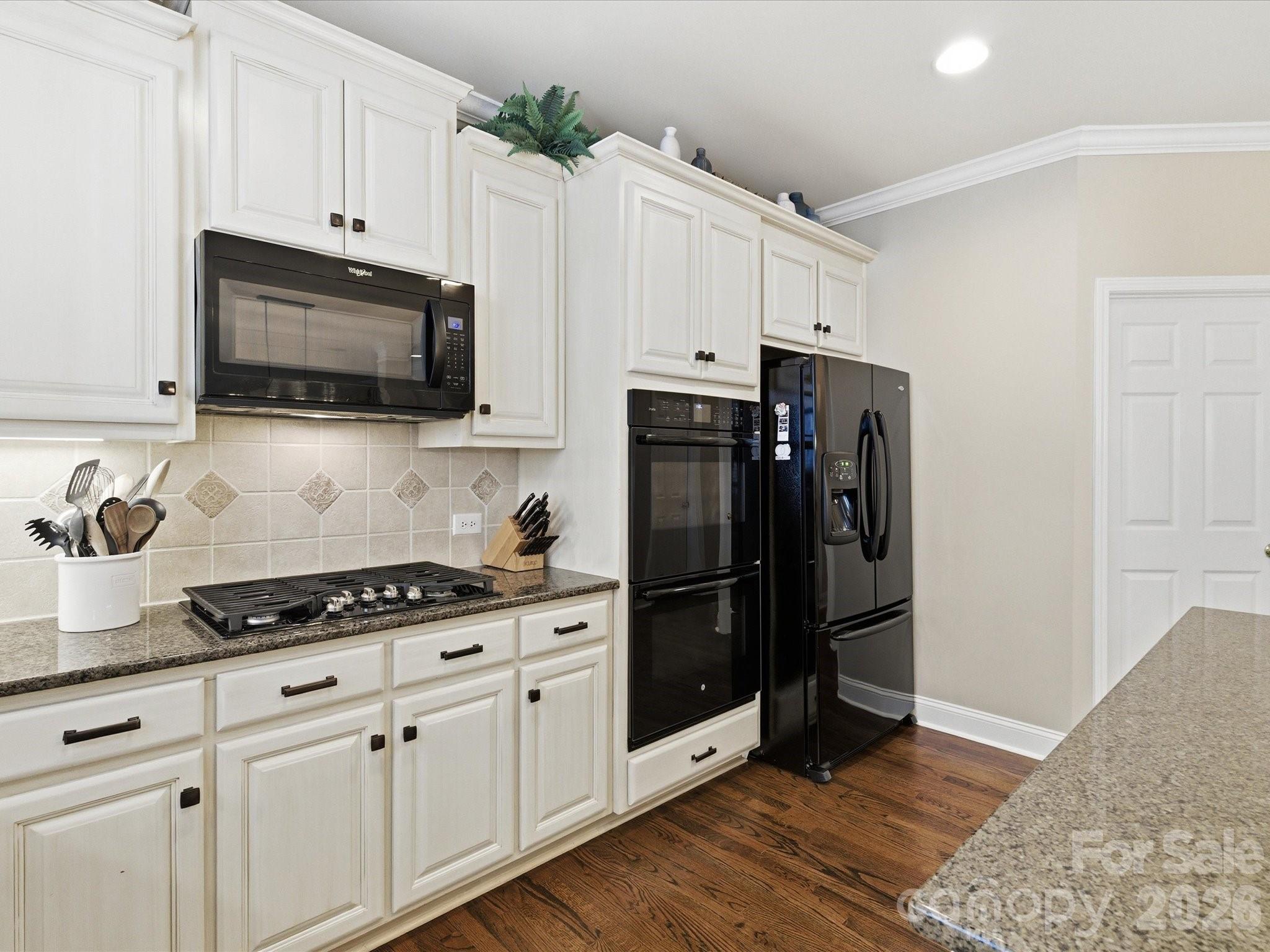 6318 Riverside Oaks Drive Huntersville, NC 28078 - Photo 21 of 48 a kitchen with stainless steel appliances white cabinets a stove a microwave and a refrigerator