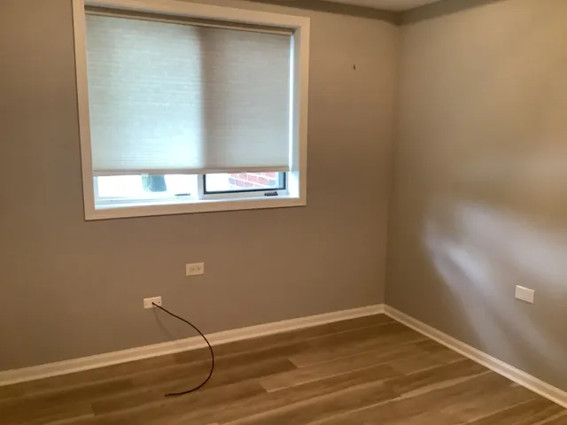 a view of a small space with wooden floor and a window