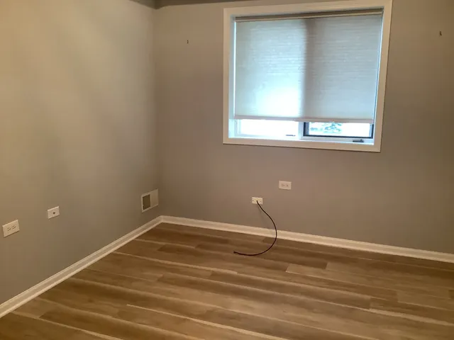 a view of a room with wooden floor and a window