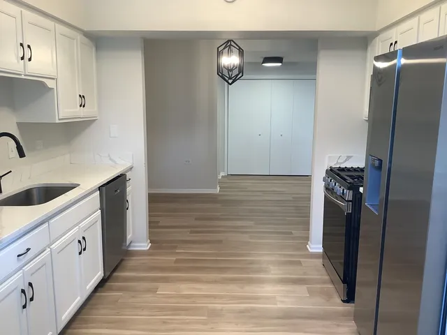 a kitchen with cabinets and wooden floor