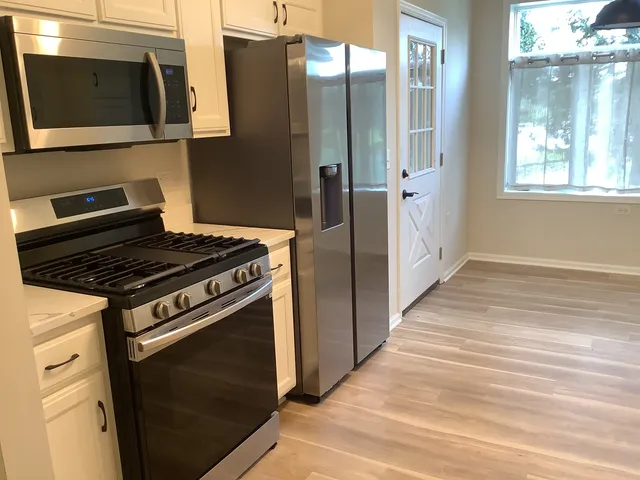 a kitchen with stainless steel appliances granite countertop a stove and a microwave