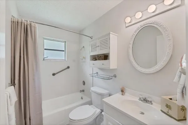 a bathroom with a toilet sink a mirror a bathtub and shower