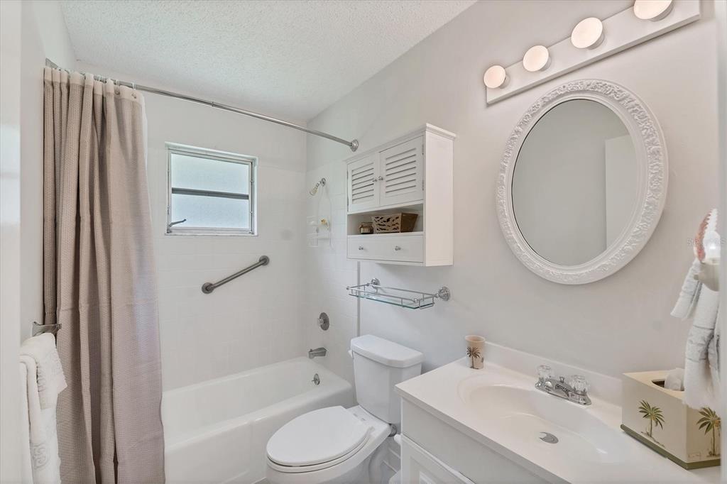 534 Sutton Place Longboat Key, FL 34228 - Photo 18 of 47 a bathroom with a toilet sink a mirror a bathtub and shower
