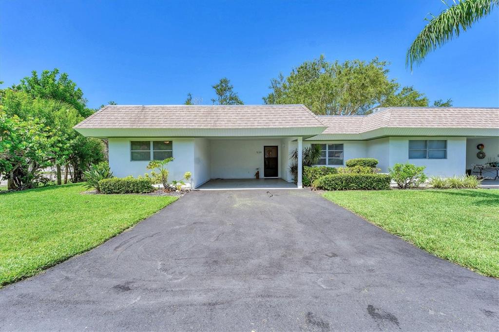 534 Sutton Place Longboat Key, FL 34228 - Photo 5 of 47 a front view of a house with garden