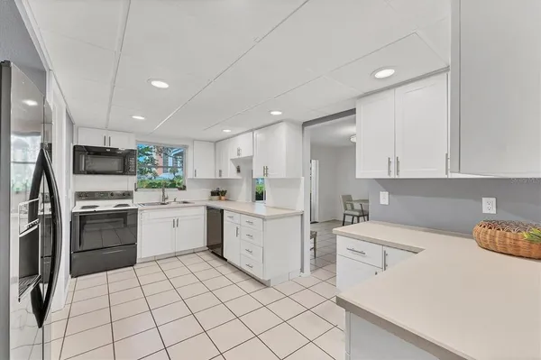a kitchen with white cabinets stainless steel appliances and sink