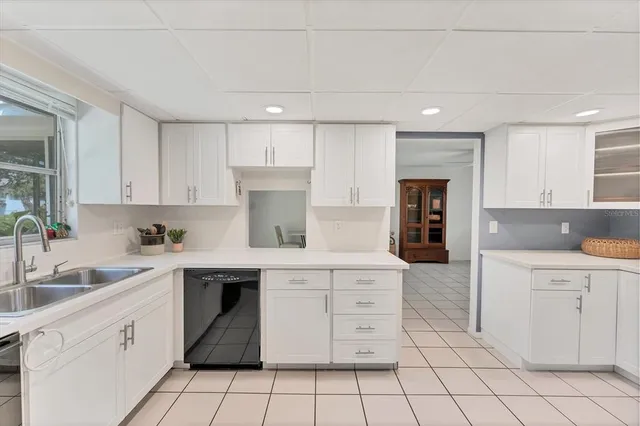 a kitchen with white cabinets appliances and sink