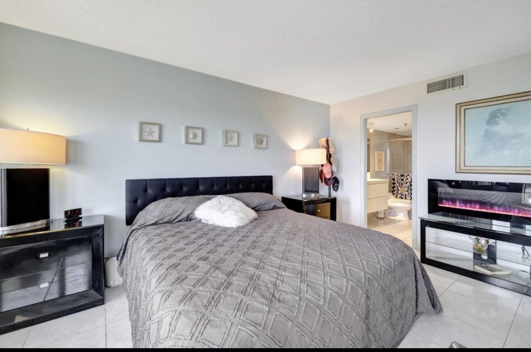 3870 North Hwy A1A, Unit 1011 Hutchinson Island, FL 34949 - Photo 12 of 30 a spacious bedroom with a bed and a flat screen tv