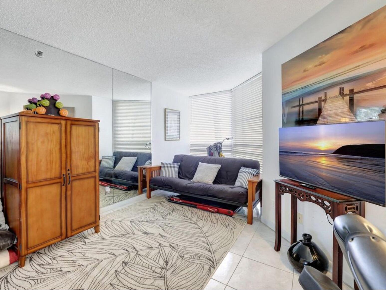 3870 North Hwy A1A, Unit 1011 Hutchinson Island, FL 34949 - Photo 16 of 30 a living room with furniture a dining table and a refrigerator